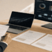 Mesa de trabajo en oficina moderna con portátil, documentos y panel de evaluación de cumplimiento, imagen destacada sobre el EU AI Act para empresas.